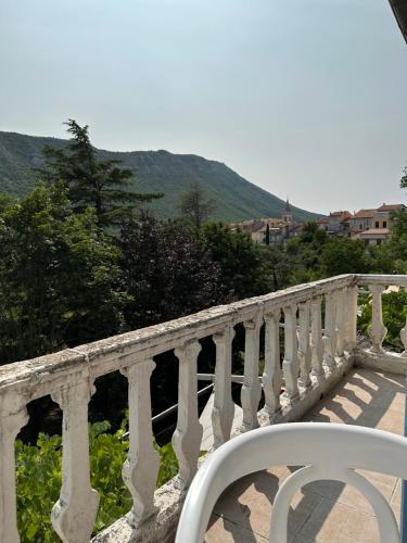 une balustrade blanche sur un pont avec des montagnes en arrière-plan dans l'établissement Les Terrasses, à Montéglin
