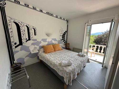 a bedroom with a bed and a large window at Les Terrasses in Montéglin