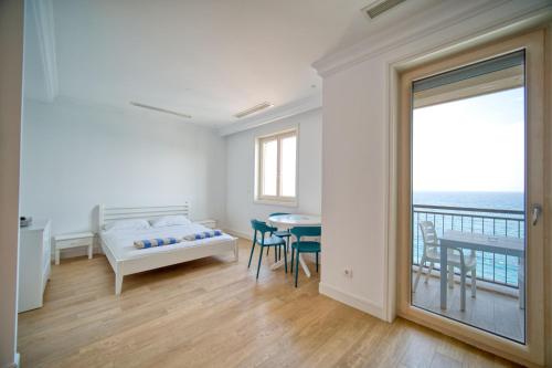 um quarto com uma cama, uma mesa e uma varanda em Studio Apartment By 2bhome em Radovići