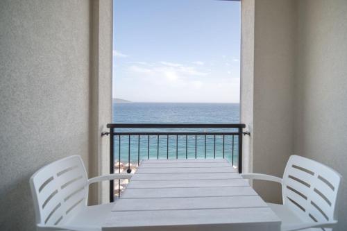 uma mesa e cadeiras numa varanda com o oceano em Studio Apartment By 2bhome em Radovići