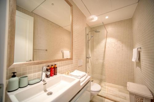 uma casa de banho com um lavatório, um chuveiro e um WC. em Studio Apartment By 2bhome em Radovići