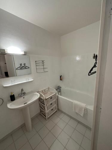 a white bathroom with a sink and a bath tub at Les Terrasses in Montéglin