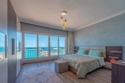 Hurghada marina apartment sea view في الغردقة: غرفة نوم مع سرير وإطلالة على المحيط