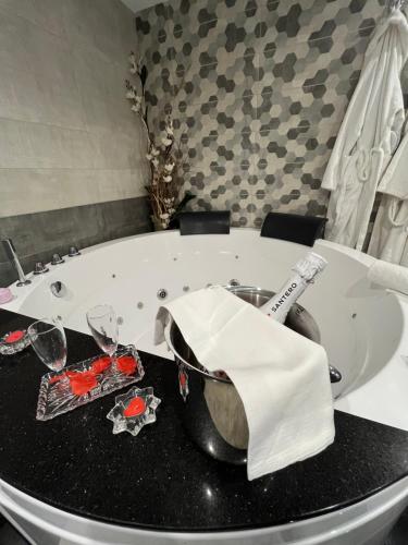a bathroom with a tub with a table with glasses at Vista Mare Apartments in Giardini Naxos