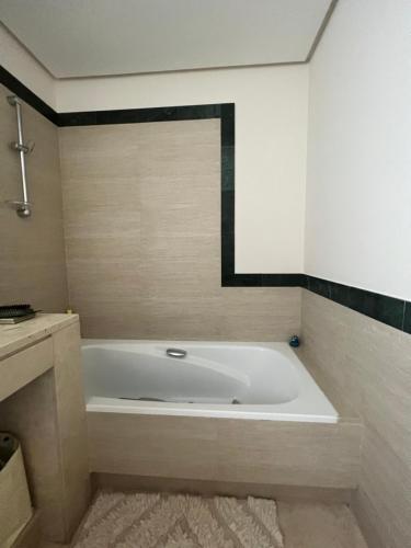 a white bath tub in a bathroom with a rug at Altos De La Quinta II Apartment Marbella in Marbella