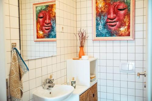 baño con lavabo y 2 cuadros en la pared en Loving energy appartment, en Mrše