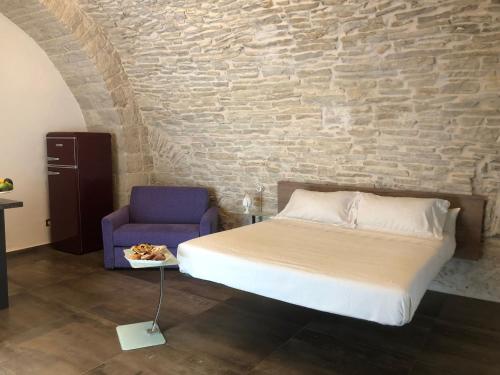 ein Schlafzimmer mit einem Bett und einem blauen Stuhl in der Unterkunft MC 1640 in Quasani