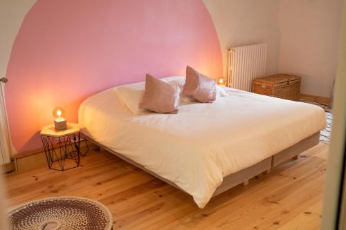 um quarto com uma grande cama branca e 2 almofadas em Sur mon chemin chambres d'hôtes em Cahuzac-sur-Vère