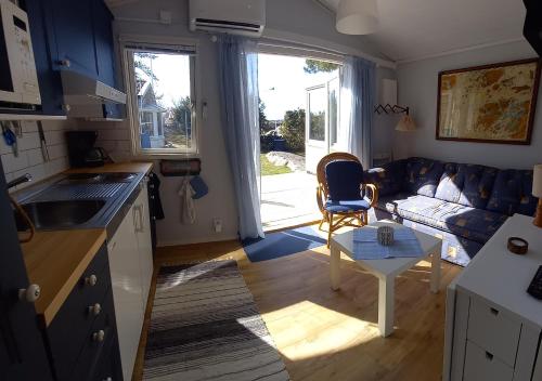 eine Küche und ein Wohnzimmer mit einem Sofa und einem Tisch in der Unterkunft Tofte Guesthouse nära hav, bad och Marstrand in Lycke