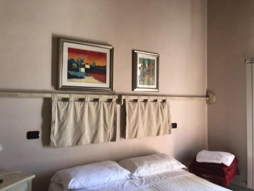 a bedroom with a bed and two pictures on the wall at Il Capisterium in Norcia