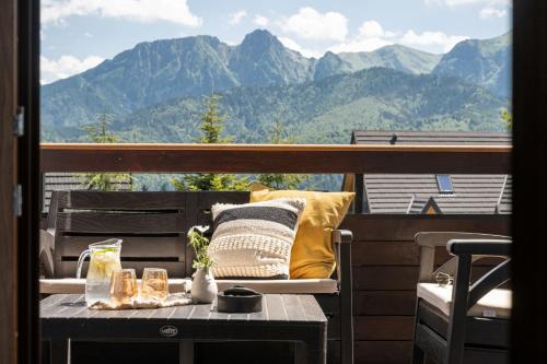 una mesa en un balcón con vistas a las montañas en Villa Tatrica, en Kościelisko