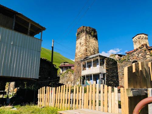 an old house with two towers behind a wooden fence at Ela in Ushguli