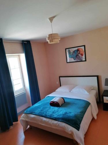 een slaapkamer met een groot bed en een blauwe deken bij le valoria delph et greg 
