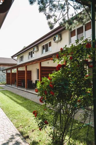 a house with red roses in front of it at Sonyachni bungalo in Melʼniki