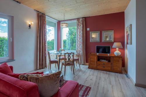 a living room with a couch and a table with chairs at La Rosa Gialla Bio Apartments & rooms in Barolo