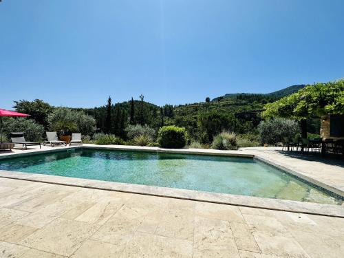a swimming pool with blue water in a yard at Maison en pierre, piscine, spa in Buis-les-Baronnies