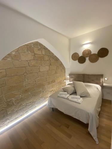 um quarto com uma cama e uma parede de pedra em B&B Vin e Va em Bari