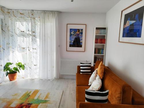 een woonkamer met een bank en een raam bij Apartament Amber Comfort z prywatnym miejscem parkingowym in Kołobrzeg