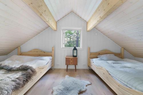 2 camas en un dormitorio ático con ventana en Cabin in Malangen, en Mestervik