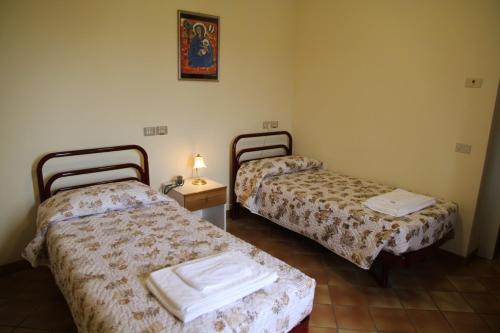 Cette chambre comprend deux lits et une table avec une lampe. dans l'établissement Hotel Madonna di Loreto, à Loreto