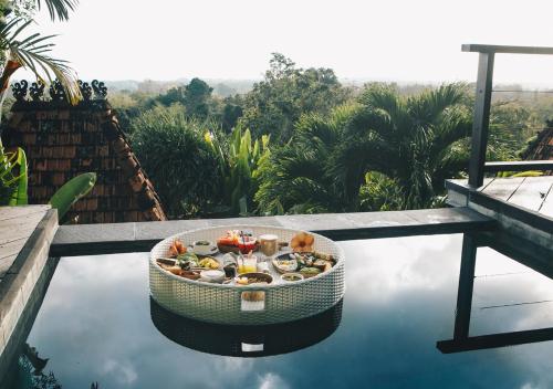 ウルワツにあるWhite Tortoise Eco Villa'sのプールの上に座った食べ物
