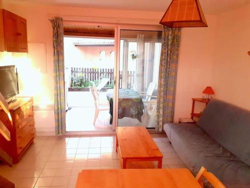 een woonkamer met een bank en een tafel en een balkon bij Pavillon Duplex T2/terrasse in Cap d'Agde