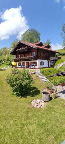 ein Haus auf einem Hügel mit einem grünen Hof in der Unterkunft Opas Bergchalet in Halblech