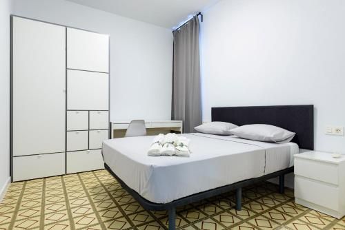 a bedroom with a bed with two white shoes on it at Bieti Castellon in Castellón de la Plana