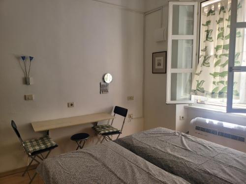 a bedroom with a bed and a table and chairs at Studio Labirint in Piran