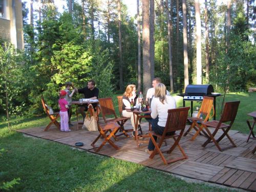 a group of people sitting on a patio with a piano at Hotelli Mäntylinna in Ylihärmä