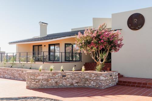 a house with a stone wall and a tree at VILLA DOS R'S in Avis