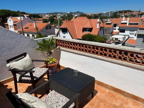 a balcony with a table and chairs on a roof at Eco Ljmonade Hostel in Cascais