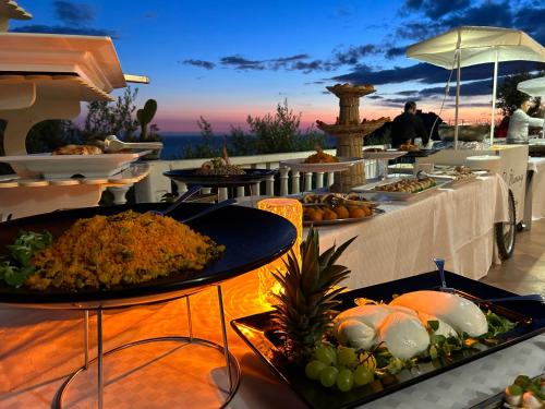 a table with plates of food on top of a restaurant at La Collina sul Mare in Palma di Montechiaro