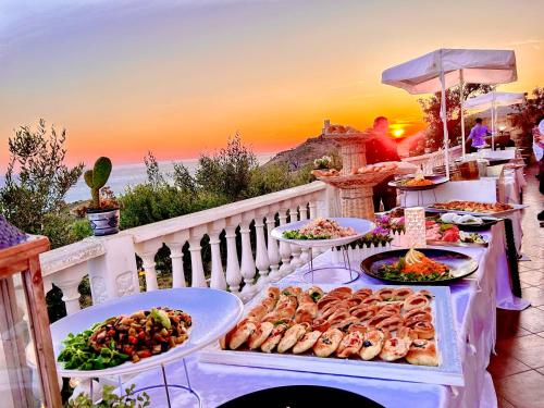 a buffet with many plates of food on a table at La Collina sul Mare in Palma di Montechiaro