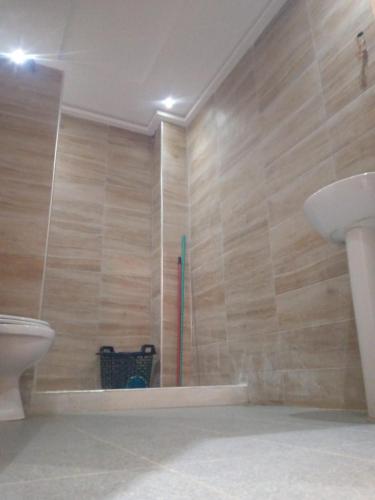 uma casa de banho com um chuveiro, um WC e um lavatório. em Ouma yanis em Kenitra
