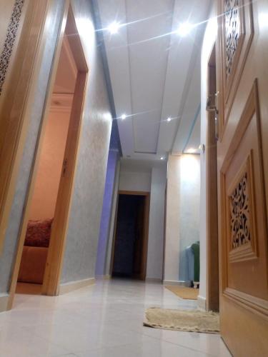 um corredor de um edifício com uma porta e um tapete em Ouma yanis em Kenitra