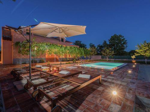 a house with a swimming pool and an umbrella at Charming holiday home with private pool in Donji Zemunik