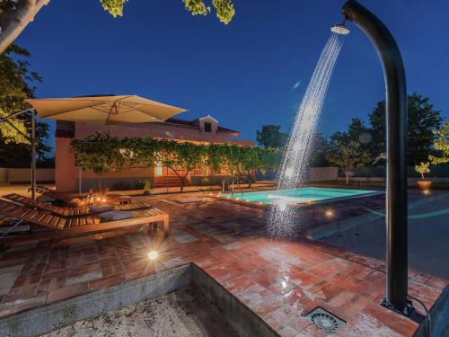 een fontein midden op een patio met een zwembad bij Charming holiday home with private pool in Donji Zemunik