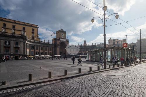 une rue de la ville avec une tour de l'horloge au loin dans l'établissement Maison Dante, à Naples