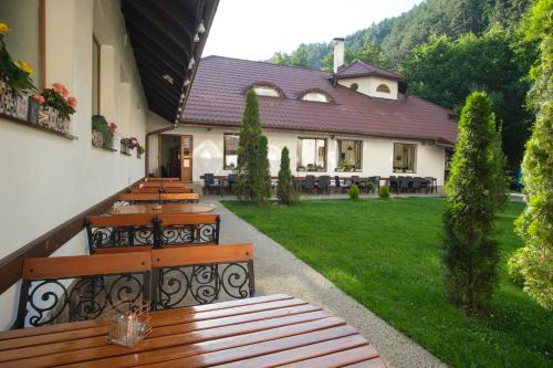 a row of wooden benches on a building with a yard at Pensiunea Sibiel in Sibiel