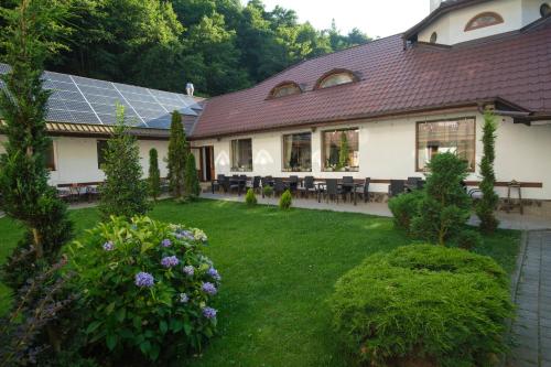 a house with a yard with benches and solar panels at Pensiunea Sibiel in Sibiel