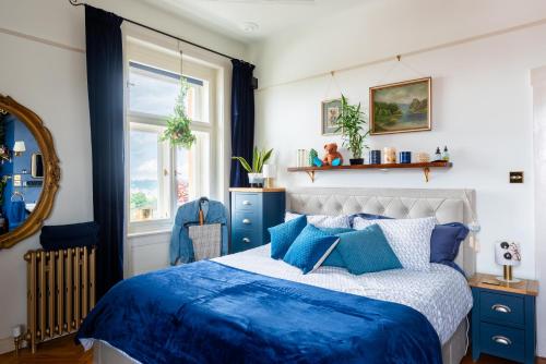 a bedroom with a blue and white bed and a window at Victoria Design Stays - Premium Apartment Ohrada in Prague