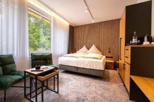 諾德奈的住宿－Hotel Südblick，卧室配有1张床、1张桌子和1把椅子