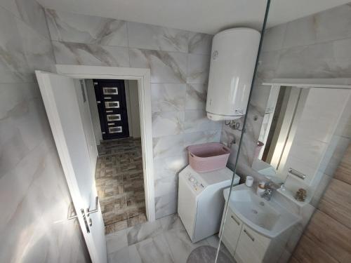 a small bathroom with a toilet and a sink at Apartman "MEDENI" in Bihać