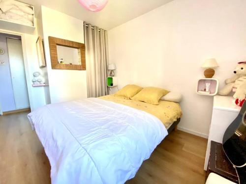 - une chambre avec un grand lit blanc et des oreillers jaunes dans l'établissement Beautiful apartment close to every spot of Deauville, à Deauville