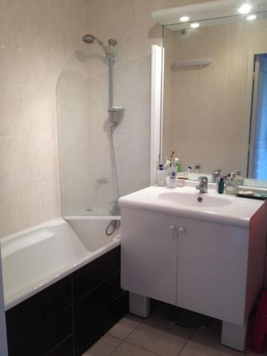 une salle de bain avec un lavabo et une baignoire et un lavabo dans l'établissement Beautiful apartment close to every spot of Deauville, à Deauville