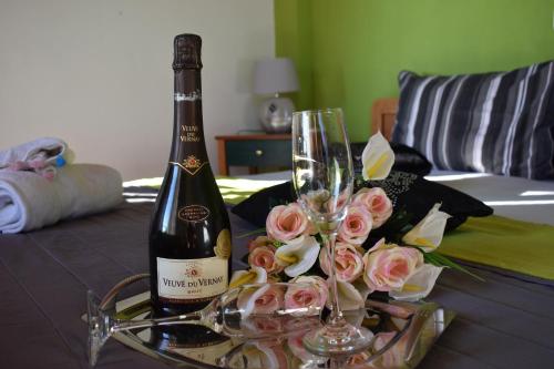 Studios Centro 5 - 2nd Floor في بوتوس: زجاجة من الشمبانيا والورود على الطاولة
