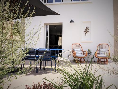 een patio met 2 stoelen en een tafel op een huis bij Le Cémarose: spa, jardin, terrasse et jolie vue au cœur d'Epernay in Épernay