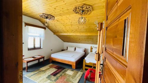 a small bedroom with a bed and a wooden ceiling at Denis House - Private Rooms -Guest House-Hotel-Gjirokastra in Gjirokastër