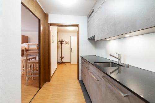 a kitchen with a sink and a counter top at Hotel Sonne in Wildhaus
